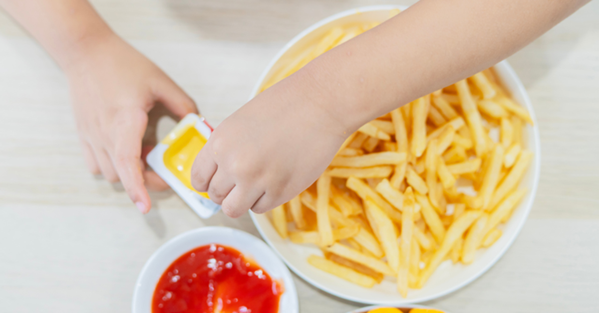 Übergewicht bei Kindern: Bild zeigt Pommes mit Ketchup und Mayo auf einem Teller.