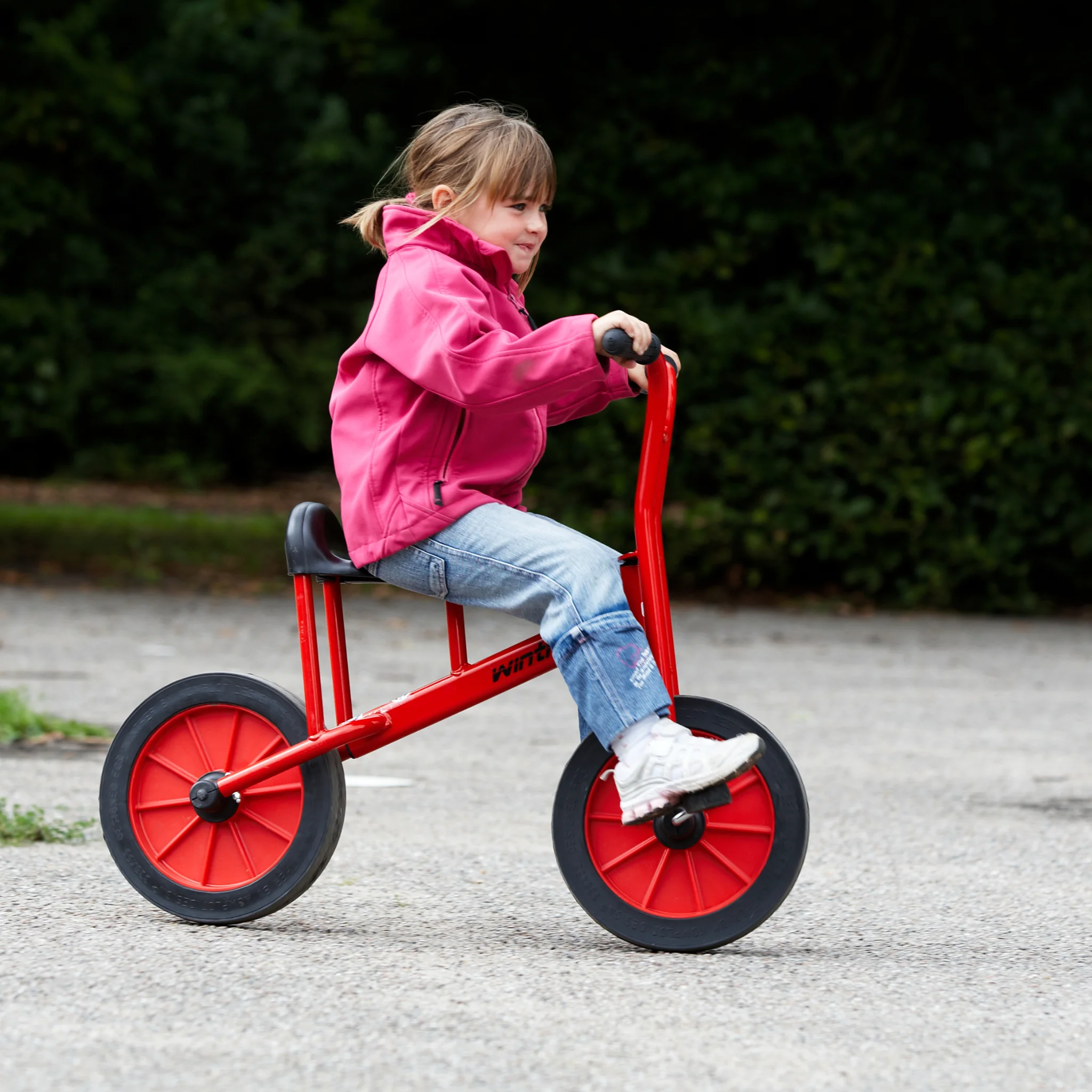 Kinderfahrzeug, Laufrad, rote Räder, Pink Jacke, Jeans