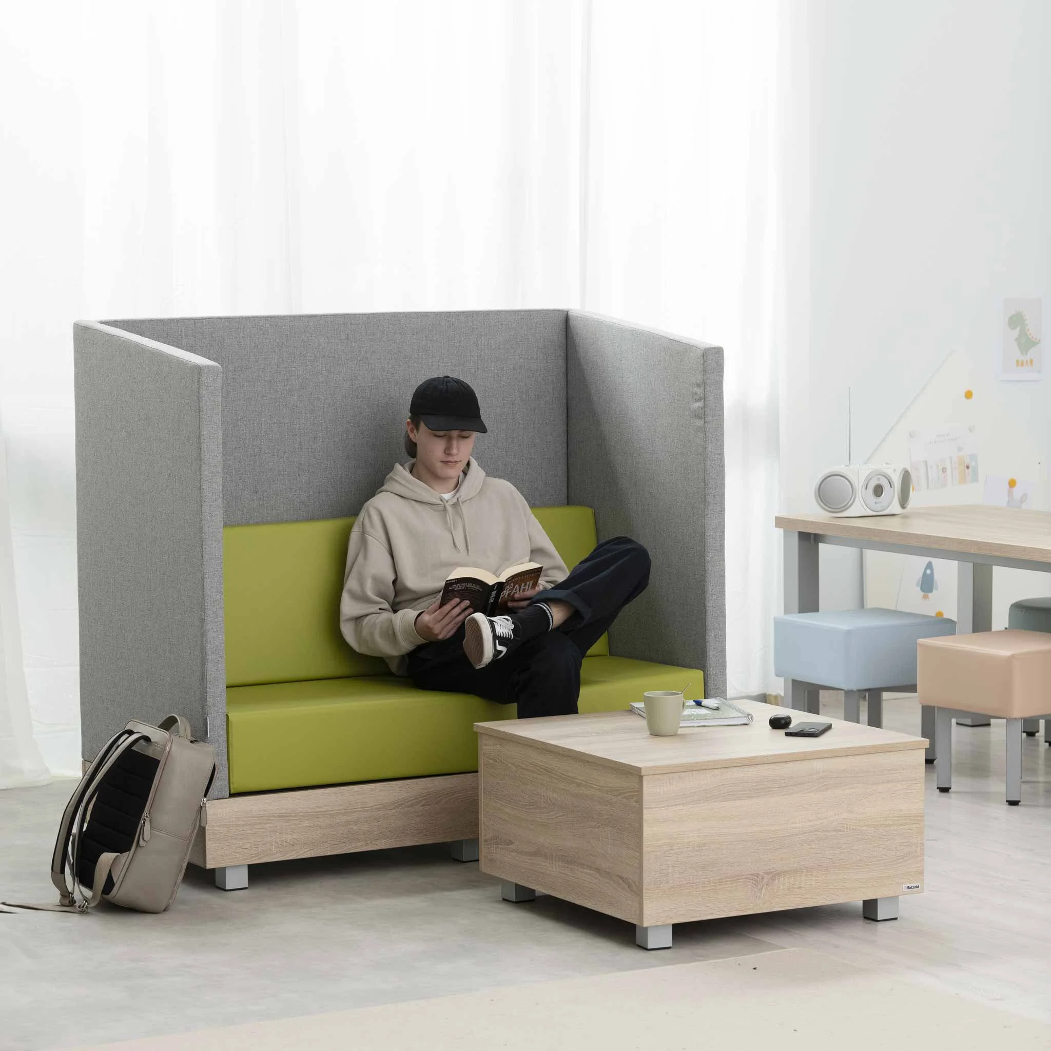Sofa mit hoher Rückenlehne, Lounge-Sitz, grüne Polsterung, Kaffeetisch, Rucksack