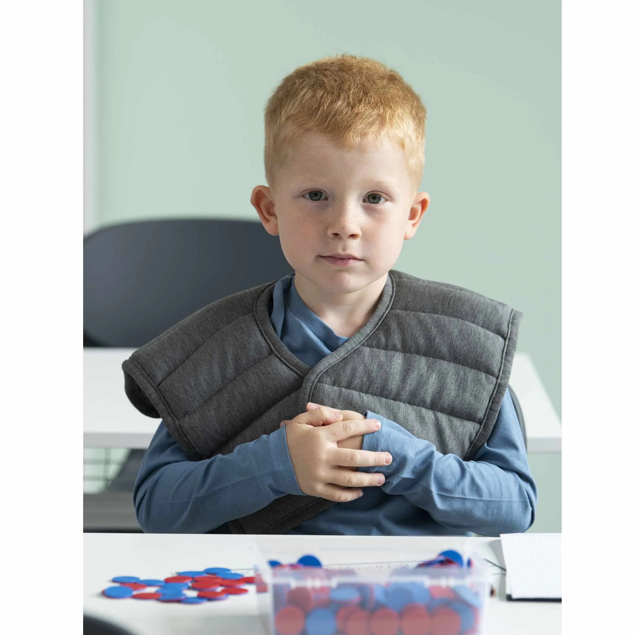 Kindergarten, Kind,  gepolsterte Weste, blaues Oberteil, Spielsteine