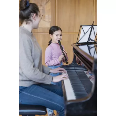 Kinderinstrument, Klavier, Schülerin mit Klarinette, Musikunterricht, Piano zusammen mit Lehrerin