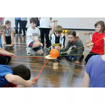 Gruppenaktivität, Kinder-Sport, Fallschirmspiel, orange Ball, Indoor-Gymnastik