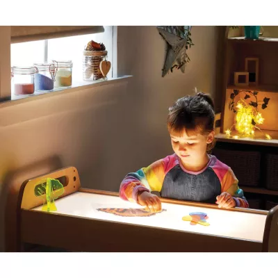 Kinderarbeitstisch, Lichttisch, Papierbögen, buntes Sweatshirt, Kinderzimmer
