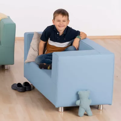 Kind, blaues Sofa, Sessel, Hausschuhe, Teddy-Spielzeug