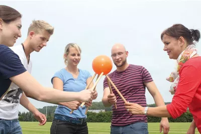 Gruppe von Personen, Outdoor-Aktivität, Ballspiel, Trommelähnlicher Ball, Werfen mit Stöcken